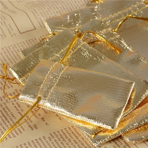 Detail of golden drawstring pouches with metallic texture on vintage background