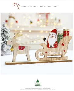 Detail of wooden Christmas sleigh ornament with reindeer and Santa on a festive desk
