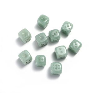 Macro shot of 10 green jade stones 15mm six-sided dice set on a white background