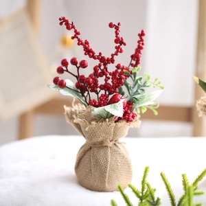 Mini artificial Christmas tree with red berries and burlap base for desk decor