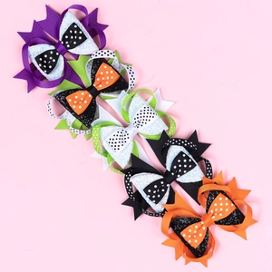 Detail of colorful Halloween layered bow hair clips in purple, green, orange and glitter white