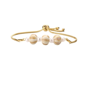 Dettaglio di un bracciale dorato regolabile con perle in ceramica a spirale e bianche
