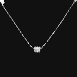 Macro detail of silver cylinder pendant necklace featuring pavé set clear crystals