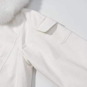 Detail of white padded jacket showing soft faux fur collar and utility sleeve pocket