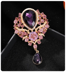 Macro shot of purple crystal brooch with gold alloy setting on black velvet box