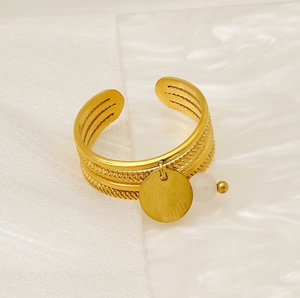Detailed close-up of adjustable 18K gold-plated steel ring with white bead and metal disc
