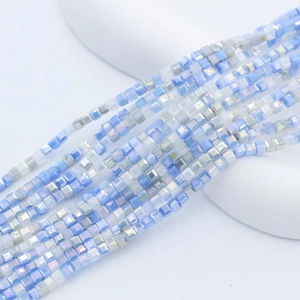 Macro view of 2mm square crystal glass beads with iridescent light blue and white finish