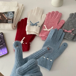 Detailed view of colorful knit gloves with bow accents and polka dots in various colors