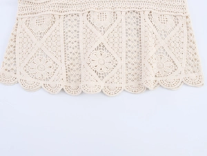 Detailed macro view of the cream crochet knit top featuring a scalloped floral hemline