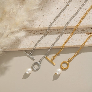 Detail view of gold and silver paperclip necklaces with OT buckle and pearl pendant