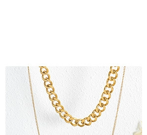 Detail of layered gold-plated chunky Cuban and flat curb chain necklace set