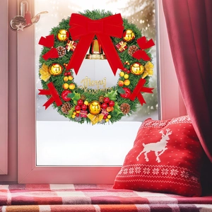 Detailed view of a Christmas wreath with red bows, golden bells, and Merry Christmas sign