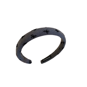 Grey bow-knot headband with textured fabric and handmade label for elegant hair styling