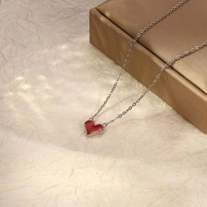 Détail macro du pendentif coeur rouge avec bordure milgrain sur chaîne argent