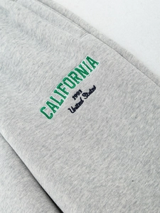 Détail de la broderie California 1993 sur le tissu en polaire de coton gris chiné