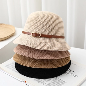 Detail of four knit bucket hats in beige, pink, caramel, and black with leather buckle strap