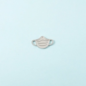 Détail d'un pendentif masque en acier inoxydable argenté poli pour la création de bijoux