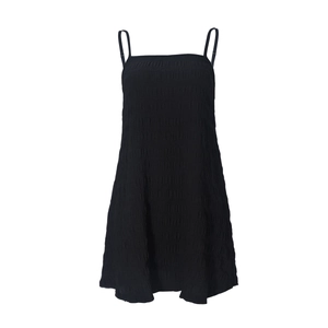 Detail of black backless camisole dress featuring smocked fabric texture and pleats