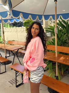 Women's pink crewneck sweatshirt with 'Kind' print and zebra pattern mini skirt