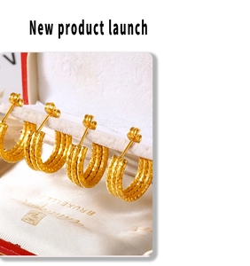 Close-up of golden multi-layer hoop earrings with geometric diamond pattern in jewelry box