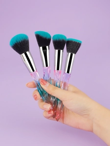 Detail of gradient crystal handles and dual-tone bristles on four professional makeup brushes