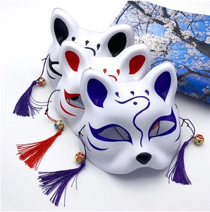 Detail of hand-painted Japanese fox masks with decorative tassels and small bells