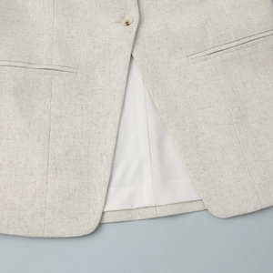 Detail of oatmeal cotton linen blazer with welt pockets and faux tortoise button