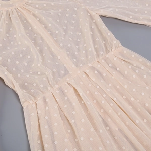 Detail of apricot mesh dress featuring puff sleeves and flocking polka dot pattern