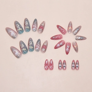 Detailed flat lay of Y2K almond press-on nails with silver chrome hearts and gradients