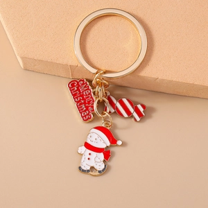 Close-up of Christmas keychain with gold ring, snowman, candy cane and red logo charms