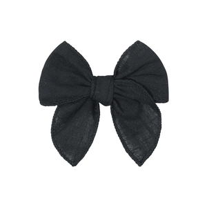 Detailed close-up of a handmade black cotton linen fabric bow hair clip for children