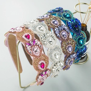 Detail of five colorful crystal and pearl beaded wide headbands on a display rack