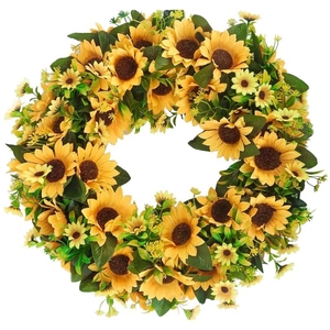 Vibrant artificial sunflower wreath with lush green leaves on white background