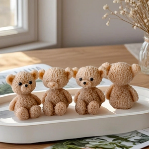 Detailed view of four brown teddy bear shaped aromatherapy candles on an oval white tray