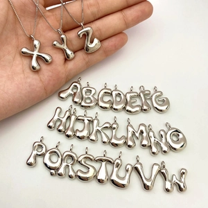 Close-up of polished silver balloon letter pendants showing smooth metallic texture