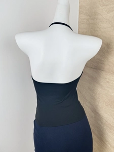 Detail view showing the open back design of a black halter top on a mannequin