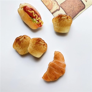 Detail shot of 3D realistic resin food charms including hot dog and croissant shapes