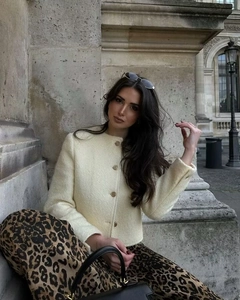 Giacca corta in lana beige alla moda indossata con pantaloni leopardati da una modella