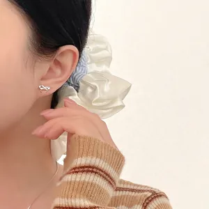 S999 sterling silver bow knot stud earrings with polished finish on female model