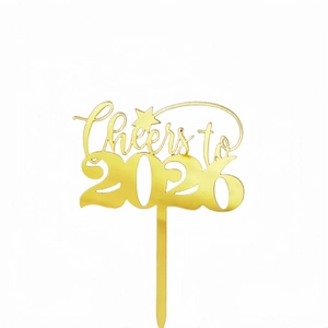 Close-up of a golden acrylic Cheers to 2026 cake topper with a reflective metallic finish