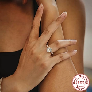 Close-up of 925 sterling silver engagement ring with round clear stone on model hand