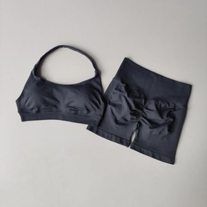 Flat lay of charcoal grey seamless ribbed yoga set including halter bra and high waist shorts