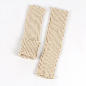 Detail of cream rib-knit leg warmers showing soft textured cable stitch patterns