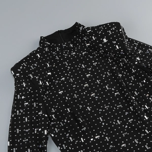 Detail of black mesh dress with turtleneck and sparkling silver rhinestone patterns