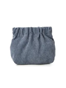 Close-up of gray-blue corduroy pouch featuring drawstring closure and soft ribbed texture