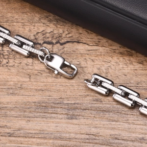 Men's hip hop handmade stainless steel link bracelet on a textured wooden background
