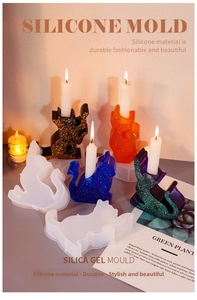 Macro shot of 3D cat silicone molds and resin candle holders with burning candles