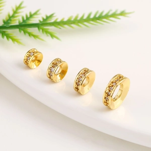 Detail of four 18k gold plated wheel spacer beads with micro-set cubic zirconia stones