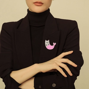 Cat mermaid enamel brooch pin in pink and white on a black suit lapel for women
