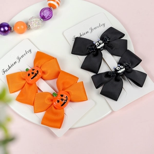 Detail of Halloween hair clips with orange pumpkin and black bat bow designs